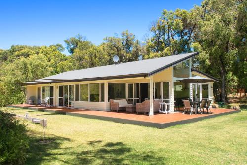 a house with a deck and a patio at Prevelly Beach Retreat in Prevelly