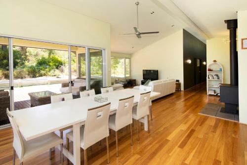 a dining room and living room with a white table and chairs at Prevelly Beach Retreat in Prevelly