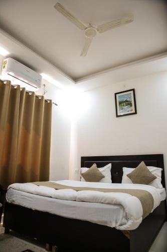 a bedroom with a large bed with white sheets and pillows at HOTEL SATYA in Dehradun