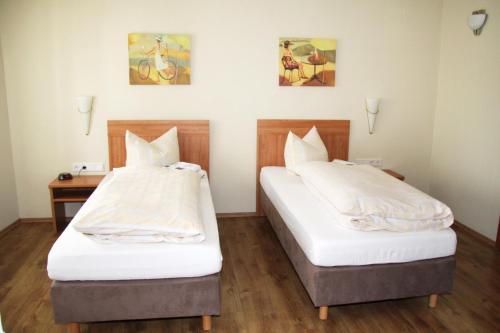 2 Betten in einem Hotelzimmer mit 2 Schlafgelegenheiten in der Unterkunft Gaststätte Wicke in Baunatal
