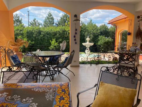 une terrasse avec une table, des chaises et une fontaine dans l'établissement La Conac, à Arad