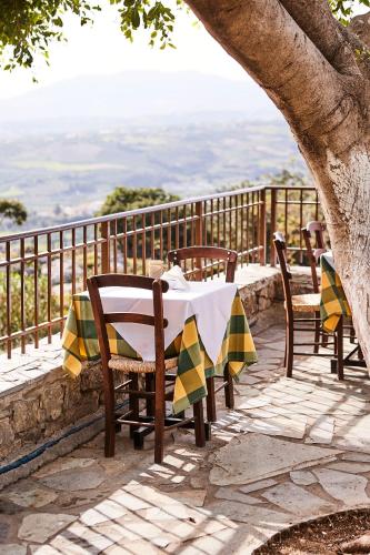 a table and chairs on a patio with a view at Arolithos Traditional Village Hotel in Tílisos