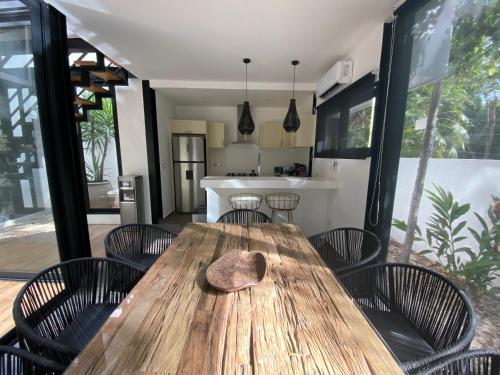 a wooden table with chairs and a hat on it at Casa Kuaan Mani TH 1 in Tulum