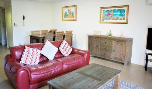 a living room with a leather couch and a table at Montana Palms Resort in Gold Coast