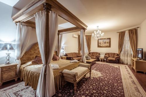 a bedroom with a canopy bed and a couch at Ichan Qal'a Premium Class Hotel in Tashkent