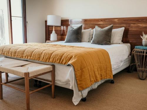 a bedroom with a large bed with a wooden headboard at Hearns Beachside Villa 7 in Port Fairy