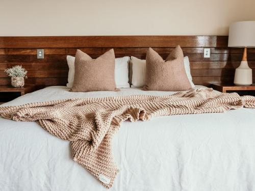 a bed with a brown blanket on top of it at Hearns Beachside Villa 7 in Port Fairy