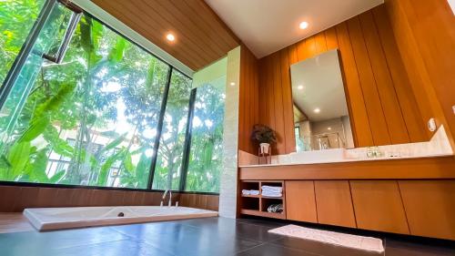 a bathroom with a large window and a tub and a sink at Vivace Khaoyai in Mu Si