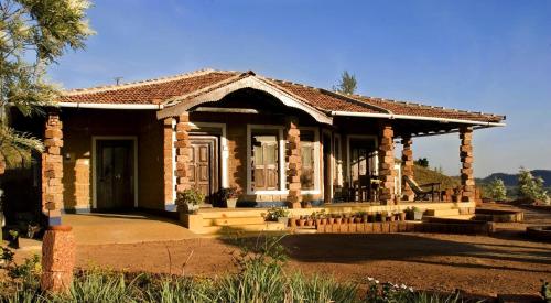 a small brick house with a porch and a porch at Jade Hills Coorg in Madikeri