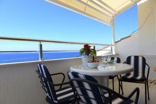 een tafel en stoelen op een balkon met uitzicht op de oceaan bij Villa Katarina in Petrcane