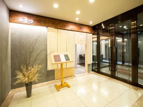 a lobby with a table with a painting on a wall at Hotel Bellclassic Tokyo in Tokyo