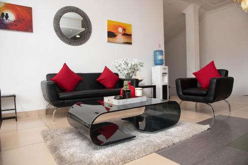 a living room with a black couch and red pillows at Chamba Valley Exotic Hotel in Lusaka