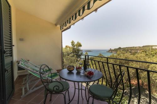 a table and chairs on a balcony with a view of the ocean at Residence Torre Delle Viole in Marina di Camerota