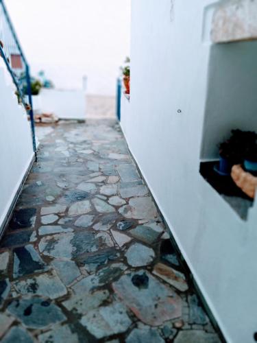 un corridoio con un passaggio in pietra con pavimento in pietra di ARGYRO'S HOUSE a Kimolos