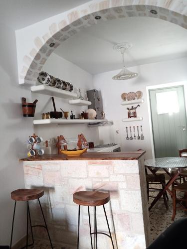 a kitchen with a stone counter with stools in front at ARGYRO'S HOUSE in Kimolos