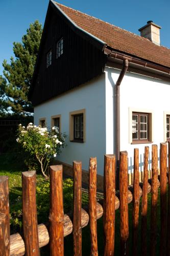 a wooden fence in front of a white house at Chalupa Barborka in Mezimesti