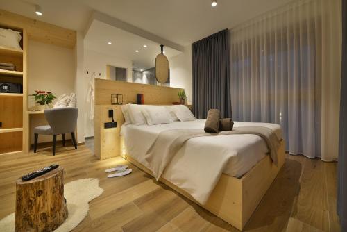 a bedroom with a large bed and a chair at Hotel Valtellina in Livigno