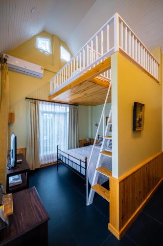 a room with a bunk bed and a staircase at Baroque Boutique Resort in Ranong
