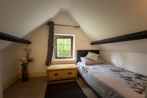 Schlafzimmer mit einem Bett und einem Fenster in der Unterkunft Pikes Barn in Taunton