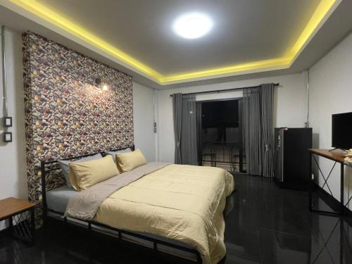 a bedroom with a large bed with a wall at Re-Live Resort in Ban Bang Phra