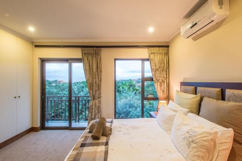 a bedroom with a bed and a large window at Zimbali Holiday Home - 3 Baluwatu in Durban