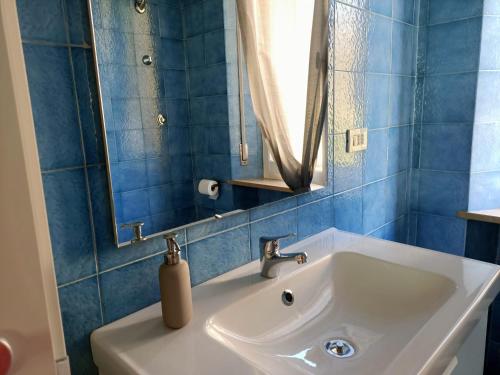 ein Badezimmer mit einem weißen Waschbecken und einem Spiegel in der Unterkunft Raffaello in Iesi
