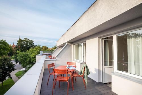 a balcony with a table and chairs on it at Tech Spa Coliving&Coworking Spaces in Druskininkai