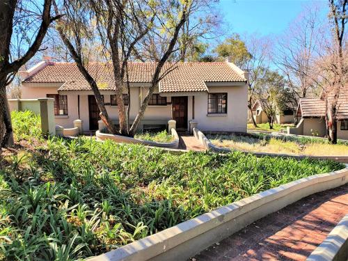 a house with a lot of plants in front of it at Premier Hotel Roodevalley in Pretoria