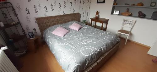1 dormitorio con 1 cama con 2 almohadas rosas en Chez Evelyne chambre d'hôtes chez l'habitant, en Verdún