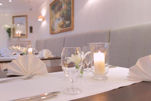 a table with two wine glasses and a candle on it at Branicki Boutique Rooms in Białystok