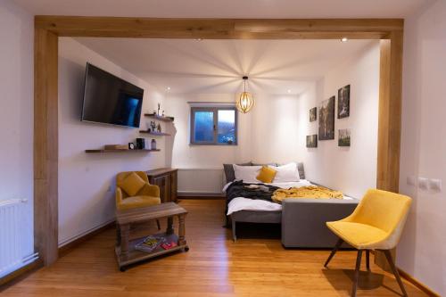 a bedroom with a bed and two chairs and a tv at Old Bakery House in Sinaia