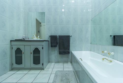 Baño blanco con bañera y lavamanos en Charlie's Spot - Norwood, en Johannesburgo