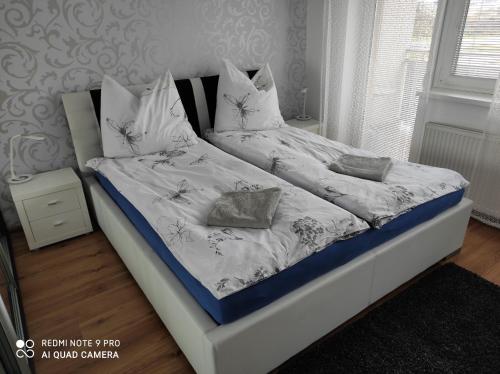 a bedroom with a bed with white sheets and pillows at Apartman MB in Poprad