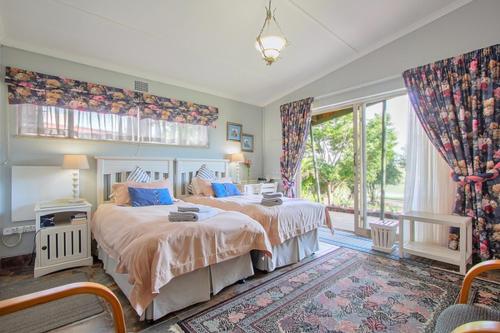 Un dormitorio con dos camas y una gran ventana. en Waterfront Guest House, en Carolina