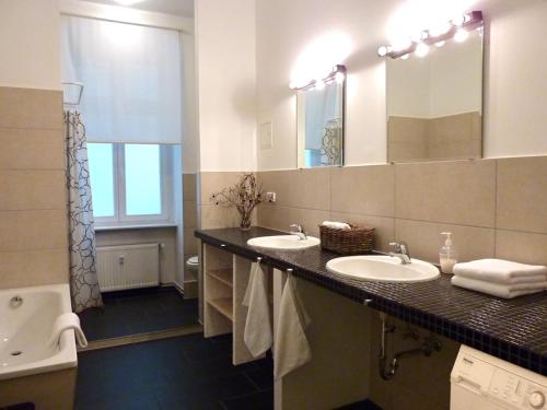 uma casa de banho com 2 lavatórios e um espelho grande em apartment25 em Berlim