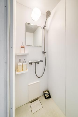 a shower in a white bathroom with a mirror at Diamond Moon Palace Takadanobaba,2 stops to Shinjuku in Tokyo