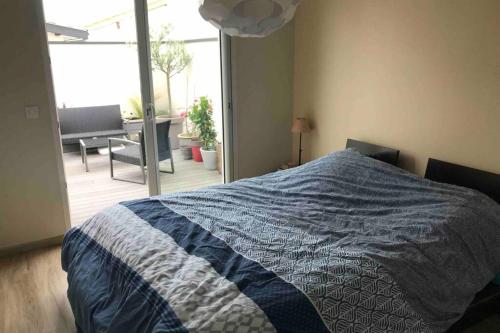 a bedroom with a bed and a view of a patio at Maison lumineuse 3 chambres bordeaux sud in Pont-de-la-Maye