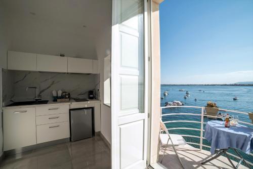 a kitchen with a view of the ocean from a balcony at Panorama Alfeo in Siracusa