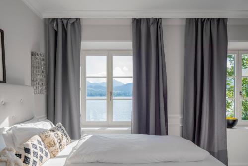a bedroom with a bed and a large window at Villa Palazzo in Tegernsee