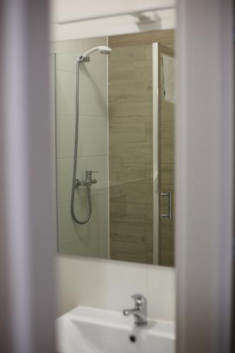 La salle de bains est pourvue d'un lavabo et d'un miroir. dans l'établissement Hotel POD RÓŻAMI, à Jedlnia-Letnisko