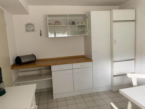 uma cozinha com armários brancos e uma bancada em FeWo25-Zimmer-am-Bodensee em Markdorf