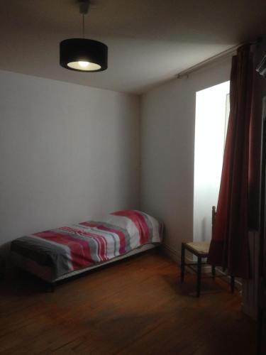 1 dormitorio con 1 cama en una habitación con ventana en Maison Guigon en Saint-Désirat
