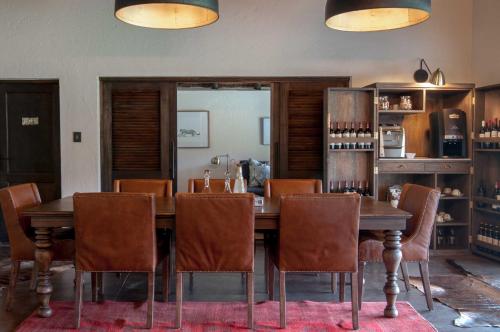 a dining room with a wooden table and chairs at Jock Safari Lodge in Skukuza