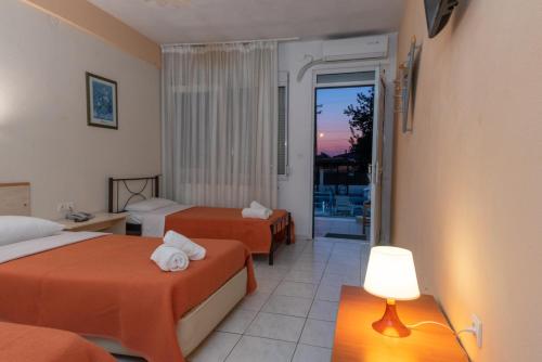 ein Hotelzimmer mit 2 Betten und einem Balkon in der Unterkunft Estia in Orestiada