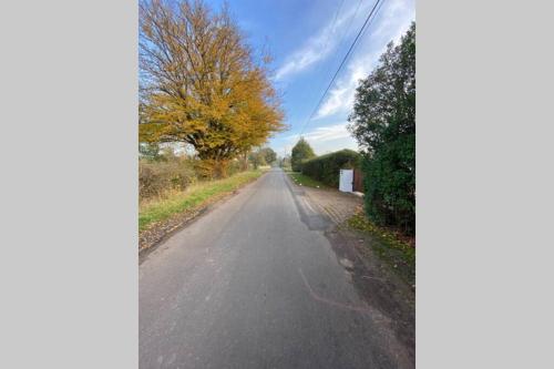 an empty road with a tree in the distance at Windsor/Ascot/Bracknell beautiful barn in Bracknell