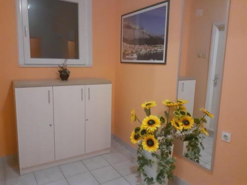 a room with a white cabinet with sunflowers at Guest House Damir in Makarska