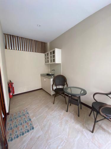 a room with a table and chairs and a kitchen at Viluveli Holiday Retreat in Hanimaadhoo