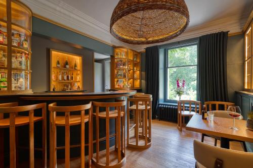 a bar in a restaurant with wooden tables and chairs at The Leathes Head Hotel in Keswick
