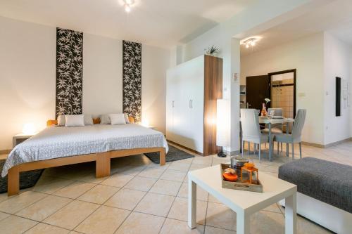 a bedroom with a bed and a living room with a table at Apartment Milojka in Crikvenica