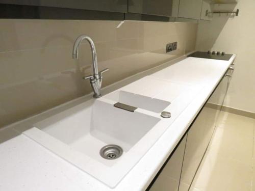 a kitchen counter with a sink in a kitchen at Modern split level flat in Croydon (south) London in London